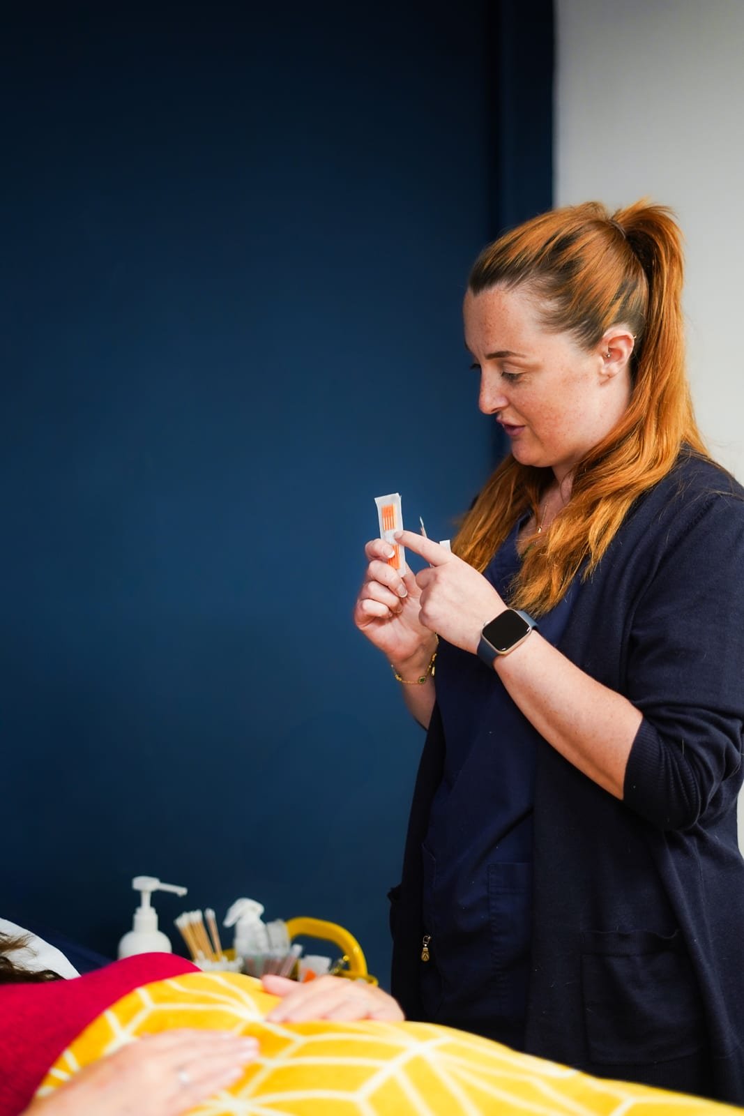 Laura preparing single-use acupuncture needles during a treatment